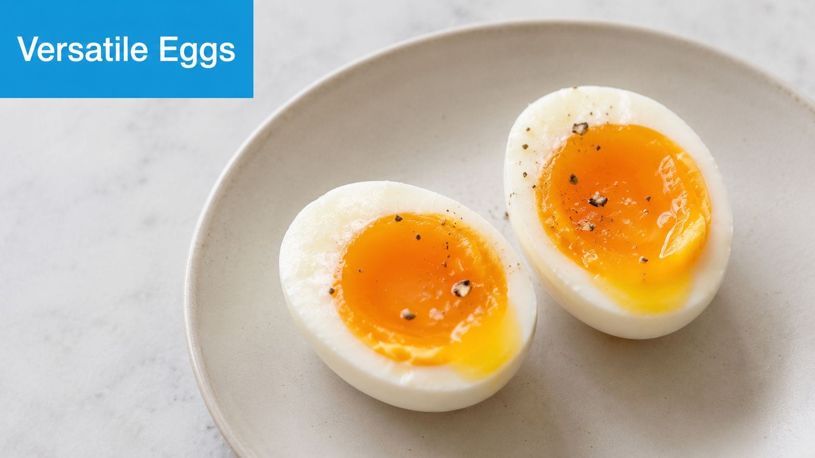 Two halves of a soft-boiled egg seasoned with black pepper resting on a neutral ceramic plate.