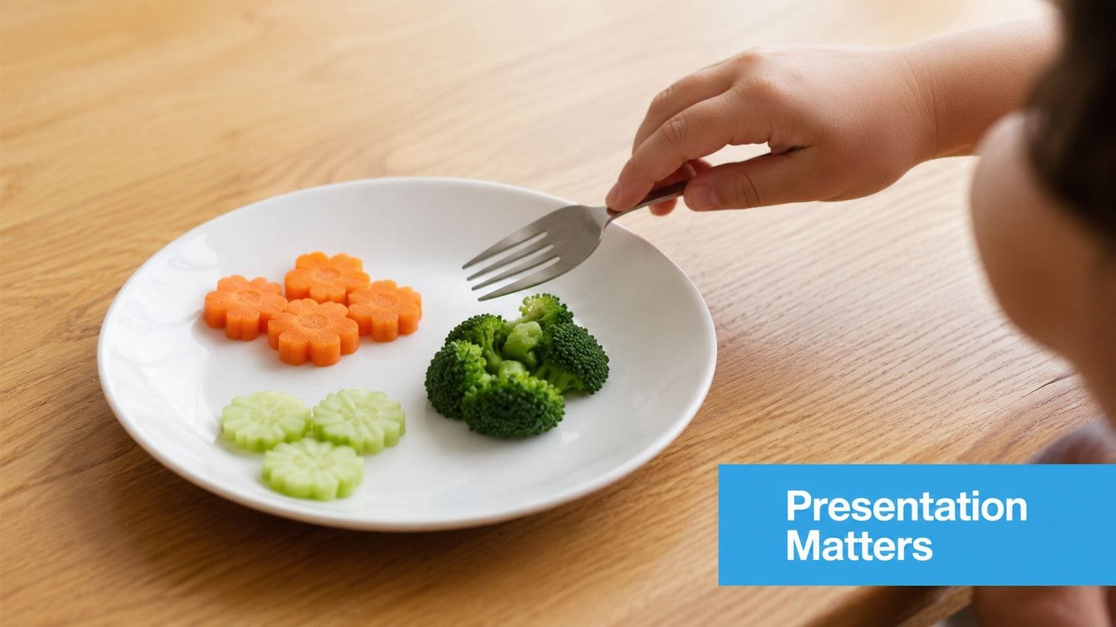 A child's hand holding a fork over a white plate with carrot flowers, cucumbers, and broccoli.