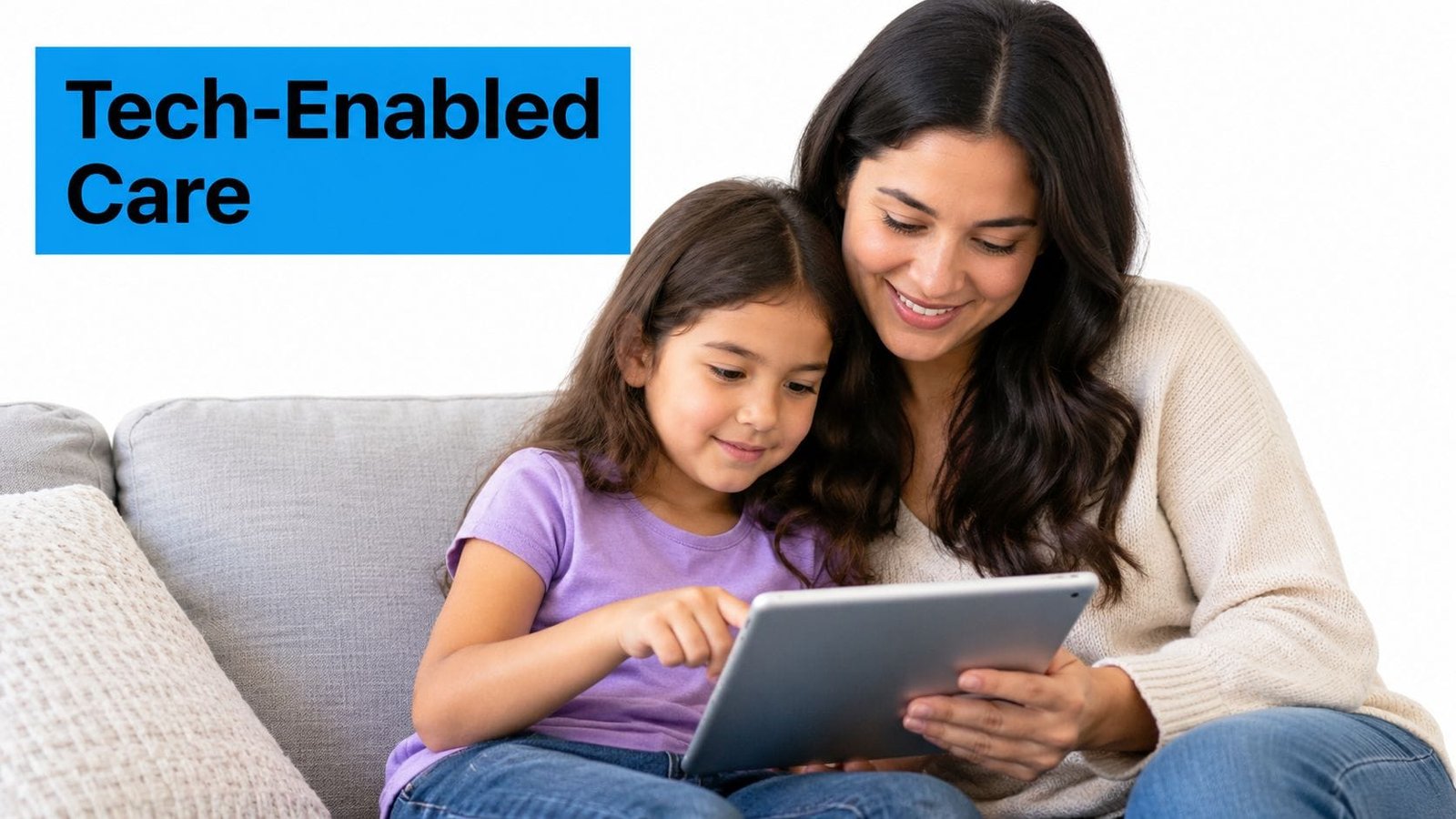 A mother and daughter smiling together while using a digital tablet at home on a couch.